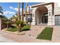 Welcoming front entrance featuring desert landscaping, a brick walkway, and an arched entryway at 7616 Gossamer Wind St, Las Vegas, NV 89139