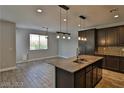 Modern kitchen with a large island, stainless steel appliances, and wood cabinetry at 7733 Donner Peak St, Las Vegas, NV 89166
