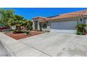 Charming single-story home with tile roof, desert landscaping, and wide driveway at 7874 Trail Boss Ct, Las Vegas, NV 89113