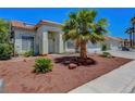 A single story home featuring desert landscaping, a palm tree, and a two car garage at 7874 Trail Boss Ct, Las Vegas, NV 89113