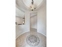 Inviting foyer with decorative tile inlay and arched doorways, enhanced by modern lighting fixture at 10410 Nostalgia Cir, Las Vegas, NV 89135