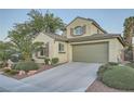 Desert landscaped two-story home with two car garage and concrete driveway, and shuttered windows at 11345 Espadrille Ct, Las Vegas, NV 89138