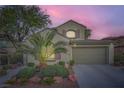 Charming two-story home with landscaped yard, desert landscaping, and attached two car garage at 11345 Espadrille Ct, Las Vegas, NV 89138