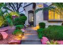 Inviting home entrance with landscaped steps and a decorative iron security door, surrounded by lush, manicured greenery at 11345 Espadrille Ct, Las Vegas, NV 89138