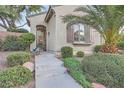 Inviting front entrance with desert landscaping and wrought iron security gate on the front door at 11345 Espadrille Ct, Las Vegas, NV 89138