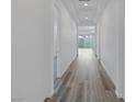 Bright hallway features modern wood-look flooring, recessed lighting, and access to various rooms within the home at 11617 Peregrine Point Ct, Las Vegas, NV 89138