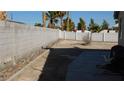 Large backyard featuring a block wall, concrete patio, and drought-resistant landscaping at 1214 Emerald Stone Ave, North Las Vegas, NV 89081
