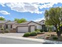 Single-story home featuring a three-car garage, desert landscaping and a tile roof at 1613 Williamsport St, Henderson, NV 89052
