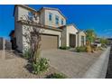 Two-story home with a two-car garage and a stone-paved driveway and walkway at 168 Robledo St, Las Vegas, NV 89138