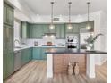 Stylish kitchen features sage green cabinets, stainless appliances, and modern pendant lighting at 20 Via Mantova # 208, Henderson, NV 89011