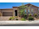 Inviting single-story home with stone accents, desert landscaping, and a well-manicured front yard at 2425 Amatrice St, Henderson, NV 89044