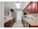 Well-lit kitchen features stainless steel appliances, granite countertops, and wood cabinets at 2451 N Rainbow Blvd # 2144, Las Vegas, NV 89108
