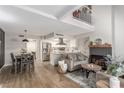 Bright open-concept living space with vaulted ceilings, modern fireplace, and laminate flooring at 2451 Old Forge Ln # 105, Las Vegas, NV 89121