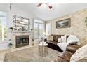 Cozy living room with fireplace, large windows, and comfortable leather sofa at 2708 Norbeck St, Las Vegas, NV 89117