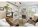 Bright living room featuring a fireplace, plantation shutters, and backyard views at 2708 Norbeck St, Las Vegas, NV 89117