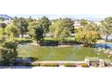 Picturesque view of a serene pond with lush green trees and manicured landscaping at 2708 Norbeck St, Las Vegas, NV 89117
