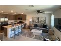 Open-concept living room and kitchen featuring modern decor, stainless steel appliances, and stylish furnishings at 3534 Alpheus River Ave, Las Vegas, NV 89106