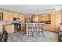 Spacious kitchen featuring wood cabinets, stainless steel appliances, and a convenient breakfast bar at 3661 Margarita Way, Las Vegas, NV 89103