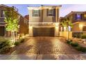 Charming two-story home featuring a two-car garage and a brick paved driveway surrounded by lush landscaping at 39 Castleton Tower Ct, Henderson, NV 89011