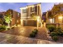 Beautiful two-story home featuring a two-car garage and a brick paved driveway with manicured landscaping at 39 Castleton Tower Ct, Henderson, NV 89011