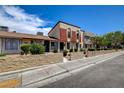 View of the townhome, landscaped yard, concrete block wall, and sidewalk at 3912 Palos Verdes St, Las Vegas, NV 89119