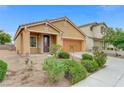 Single story home featuring a desert landscape, two car garage, and a tiled roof at 4078 Blue Manor Ln, North Las Vegas, NV 89032