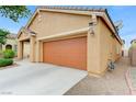 Attached two-car garage with traditional carriage doors, beige siding, and concrete driveway at 4078 Blue Manor Ln, North Las Vegas, NV 89032