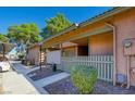 Angled exterior view of the building with peach siding, a light grey fence and sidewalk to the entryway at 413 N Lamb Blvd # F, Las Vegas, NV 89110