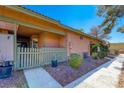 Exterior view of the front entrance with peach siding, light grey fence, and partial view of unit number at 413 N Lamb Blvd # F, Las Vegas, NV 89110