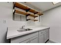 Functional laundry room featuring a utility sink, ample counter space, and convenient open shelving at 413 N Lamb Blvd # F, Las Vegas, NV 89110