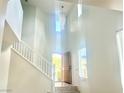 High ceiling foyer and staircase with abundant natural light beaming through the front door and clerestory windows at 4951 Ivylyn Ct, Las Vegas, NV 89122