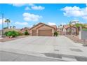 Single-story home featuring a two-car garage, desert landscaping, and a wide driveway at 5433 Escallonia St, Las Vegas, NV 89149