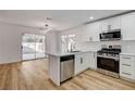 Open-concept kitchen with stainless steel appliances, white cabinets, and an adjacent dining area, great for Gathering gatherings at 5466 Silverheart Ave, Las Vegas, NV 89142