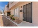 Townhome exterior showcasing a secure black metal front door with minimal desert landscaping and a light peach facade at 5939 Vegas Dr, Las Vegas, NV 89108