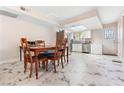 Eat-in kitchen features marble tile floor, white cabinetry, stainless steel appliances, and backyard access at 5939 Vegas Dr, Las Vegas, NV 89108