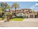 Stunning two-story single Gathering home featuring a three-car garage and well-manicured front lawn with palm trees at 764 Ricota Ct, Henderson, NV 89012