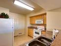 Bright kitchen with white appliances, wooden cabinets, and double sink at 8000 Badura Ave # 2009, Las Vegas, NV 89113