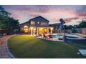 A serene backyard with a lush lawn, inviting pool, and spa creates a private oasis at 8253 Ruby Mountain Way, Las Vegas, NV 89128
