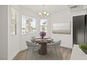 Bright dining area features a modern light fixture, a round table with seating for four, and large windows at 829 Rock Springs Dr # 201, Las Vegas, NV 89128