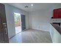 Bright living room featuring wood-look tile floors and access to the outdoor patio through sliding glass doors at 9148 Alluring Ave, Las Vegas, NV 89149