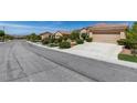 A wide street view showcases the well-manicured lawns and diverse landscaping of the neighborhood homes at , Henderson, NV 89044