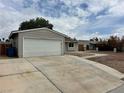 Single-story home with attached garage, long driveway, and low-water landscaping at 1004 Stone River Dr, North Las Vegas, NV 89030