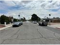 Street view showing well-maintained street with mature trees and a clear sky at 1004 Stone River Dr, North Las Vegas, NV 89030