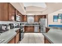 Updated kitchen featuring stainless steel appliances, wood cabinetry, tiled backsplash, and a bright overhead skylight at 10113 Walhalla Plateau Ct, Las Vegas, NV 89148