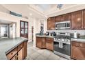 Well-lit kitchen showcasing tile floors, wood cabinets, modern appliances, and breakfast bar at 10113 Walhalla Plateau Ct, Las Vegas, NV 89148