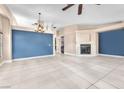 Open-concept living room with tile floors, fireplace, and blue accent wall at 10113 Walhalla Plateau Ct, Las Vegas, NV 89148