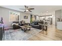 Open-concept living room features wood floors, a ceiling fan, and access to the kitchen at 10565 Olinda St, Las Vegas, NV 89179