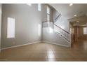 Bright, open living room with staircase, multiple windows, and tile flooring at 11900 Calle De Sol Dr, Las Vegas, NV 89138