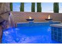Stunning pool featuring a rock waterfall, fire bowls, and pristine blue water at 12219 Crystal Shore Ave, Las Vegas, NV 89138