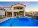 Beautiful pool area with spa, waterfall, lush landscaping, and ample seating for outdoor enjoyment at 12219 Crystal Shore Ave, Las Vegas, NV 89138
